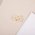 Dettaglio di un fermaglio per capelli a fiocco con perle e struttura in lega dorata - Fiocco