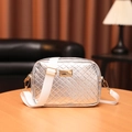 Silver woven camera bag with wide white shoulder strap on a wooden tabletop - Plaid Silver
