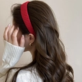 Detail of red knitted headband with woven texture on model with brown wavy hair - Burgundy