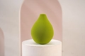 Macro view of a soft pear-shaped green makeup sponge on a white pedestal stand - Green Pear