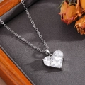 Dettaglio del ciondolo a cuore argentato con cristalli in una scatola per gioielli - Stile Cuore Completamente Incastonato Argento (T026)
