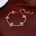 Close-up of adjustable gold-plated bracelet with red clover charms and sparkling zircons - Gold-Red
