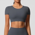 Detail eines grauen nahtlosen Yoga-Crop-Tops mit eng anliegender Passform am Model - S / Oberteile / Graphitgrau