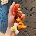 Cute brown capybara keychain in soft rubber with a yellow propeller flower on back - Dark Brown Rotating Capybara