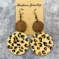 Dettaglio di orecchini western con pelle stampa leopardata e ciondoli tondi in legno scuro - Leopardo Classico