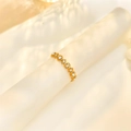Detailed view of wave-shaped gold ring with white zircons on frosted display - Adjustable Open / Gold with White Zirconia