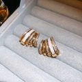 Gros plan de boucles d'oreilles en C dorées avec micro-sertissage de zircon et émail - Style Émail Doré Plaqué Or Véritable