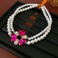 Dettaglio di collana di perle a doppio strato con ciondolo floreale in zircone rosa - Collana / Rosa Porpora
