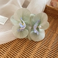 Detail von hellgrünen Stoff-Orchideen-Haarspangen mit Perlen auf einem Webkorb - Hellgrün Verlauf Orchidee (Grün) / Grün