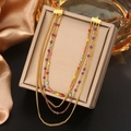 Detail of layered gold necklace featuring vibrant colorful beads on a beige display pad - Colorful Beads Four Layer Necklace (N-49)