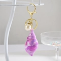 Détail du porte-clés coquillage en marbre créatif avec perle et fermoir mousqueton doré - Violet