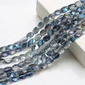 Vista dettagliata di perle in vetro cristallo blu con sfumatura iridescente su cubo - Blu Semitrasparente