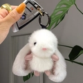 Close-up of fluffy white rabbit plush keychain with soft pink ears and metallic clasp - White Gun Black Ring
