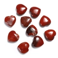 Close-up of ten polished heart-shaped red jasper gemstones on a white background - Red Jasper