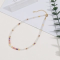 Elegante collana di perle in pietra bianca con dettagli dorati su uno sfondo estetico pulito - Collana in Pietra Naturale