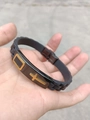 Close-up of black silicone sports bracelet with golden cross on black metal plate - Black Shell Gold Cross