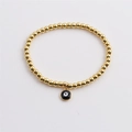 Bracelet à perles dorées minimaliste avec un pendentif œil maléfique noir et blanc sur fond blanc - Noir