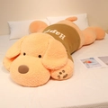 Large lying plush dog toy in orange sweater with Happy embroidery on white bedding - Olive Yellow