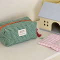 Dettaglio della trousse trapuntata a quadretti verdi con cerniera arancione e nappa rosa - Verde