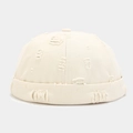 Detail of beige docker cap featuring distressed ripped holes and a rolled cuff design - Adjustable / Off White