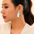 Minimalistische große silberne Tropfenohrringe mit Hochglanz-Finish auf dem Modell gezeigt - Kleiner Wassertropfen-Stil / Silber