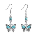 Pendientes bohemios de plata con colgantes de mariposa turquesa sobre fondo blanco - Mariposa plateada