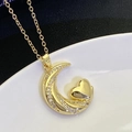 Macro detail of gold plated crescent moon and heart pendant with sparkling white zircon stones - Gold (8301)