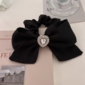 Detail of black bow hair scrunchie with sparkling heart-shaped rhinestone center - Black