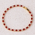 Detail van gouden tennisarmband met afwisselend rode en heldere zirkonstenen en sluiting - Rode Armband-Goud
