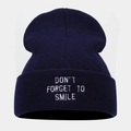 Detail of navy knit beanie featuring white embroidered Don't Forget To Smile text - One Size / Navy Blue