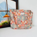 Detail shot of a floral canvas tote bag featuring a stitched label and wide shoulder strap - Colorful Ethnic Style