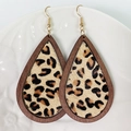 Dettaglio di orecchini a goccia in legno con inserto leopardato su piatto bianco - Legno Scuro/Pelo Leopardato