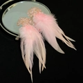 Vue macro de boucles d'oreilles en cristal rose avec glands en plumes sur un miroir - Clou d'oreille en argent - Rose / Rose
