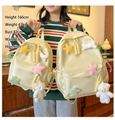 Detail view of yellow canvas school backpacks with star plush patches and white bear charms - Large / Single Bag / Yellow