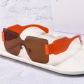 Fashionable orange wide-frame oversized sunglasses with brown lenses on a marble tray - Orange Frame Tea Lens
