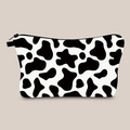 Close-up of durable black zipper on cosmetic bag with stylish cow print pattern - Cream Cow Print