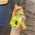 Handmade crochet sunflower keychain featuring yellow petals and gold bell charm - Sunflower