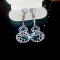 Macro shot of silver drop earrings with green stones in a double gourd shape - Hollow Wulu Tassel Style (67#)
