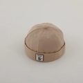 Dettaglio del berretto miki in cotone beige con toppa quadrata e ricamo della lettera S - Etichetta Lettera S - Cachi