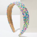 Close-up of wide headband featuring colorful candy sprinkles decoration on a white stand - Blue Gradient