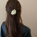 Detalle de una pinza para el cabello de metal dorado en forma de concha con rayas radiales - 5,5 cm / Concha / Dorado