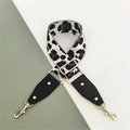Macro shot of leopard print bag strap with gold lobster clasps and black leather accents - White Coffee