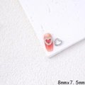 Silver hollow heart nail art charm with rhinestones shown on pink manicure background - QFX46-Hollow Rhinestone Heart (8x7.5mm)