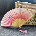 Pink folding fan with butterfly and flower patterns, bamboo ribs, and a pink tassel - Cherry Blossom Butterfly - Pink
