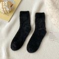 Plüschige schwarze Nerzsamt-Bodensocken in gemütlichem Flatlay für den Winter - Einheitsgröße / Schwarz