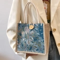Linen tote bag with teal floral pattern, woven rope handle and wooden button closure - Blue