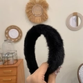 Gros plan d'un serre-tête doux en fausse fourrure noire montrant sa texture pelucheuse - Noir