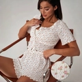 Nahaufnahme der hohlen Strickstruktur und des Blumenmusters auf weißem Pyjama-Set - S / Blumenmuster