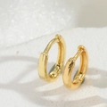 Dettaglio di orecchini a cerchio placcati in oro con finitura lucida e fascia spessa - Oro (Piccolo)