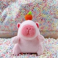 Pink plush capybara keychain with orange hat detail on macaron foam ball background - Pink Orange Style + Bead Chain